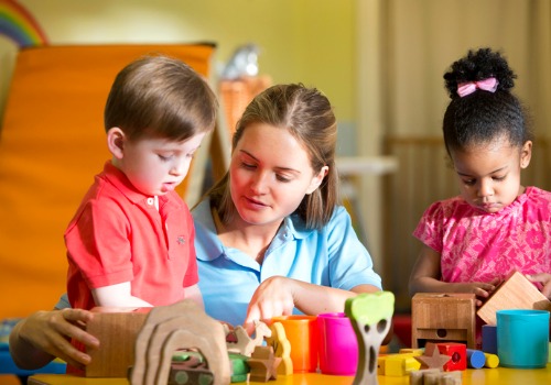 Teacher showing a young boy a toy in Childcare in Peoria IL