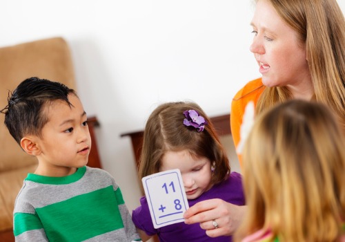 An instructor teaching children using math flash cards at a Peoria preschool