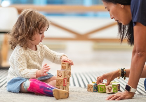 An instructor teaching a child with letter blocks at a Child Development Center in Peoria IL