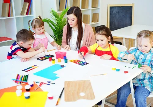 A teacher from PALS, one of the best Preschools Near Morton IL, works on an art project with kids.