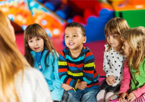 Kids at PALS, one of the top Preschools Near Morton IL, listen intently to their teacher as she talks to them.