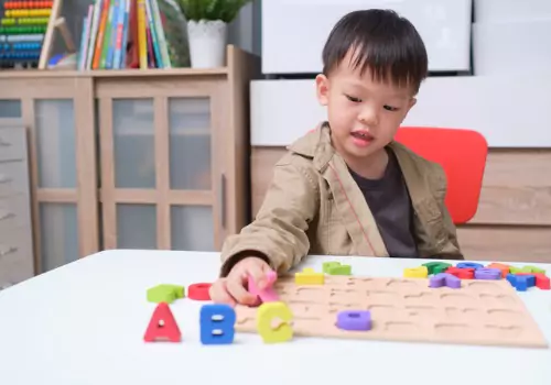 A boy plays with alphabet blocks. If you're curious about 