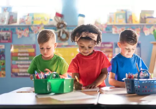 Children at PALS practice drawing and coloring. If you're asking "What’s the Difference Between Day Care and Preschool?" let us show you.