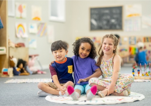 Children sit together smiling at preschool. Social Interaction is Important for Kids as they grow into adulthood.